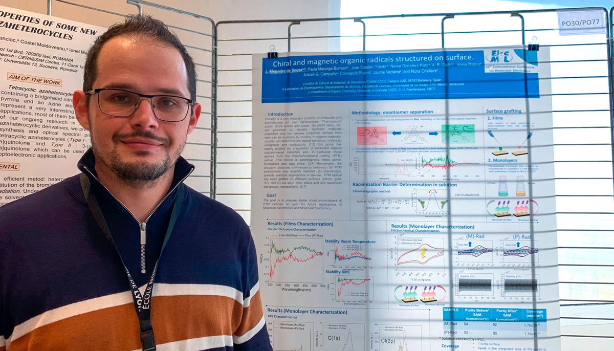 A photograph of Alejandro De Sousa next to his poster.