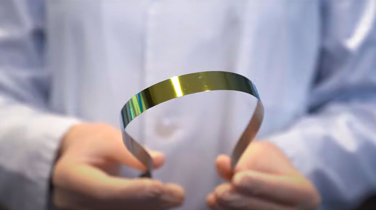 A researcher holds a flexible superconductive tape.