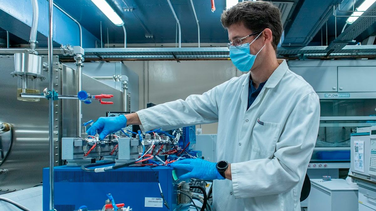 Researcher Alexandre Ponrouch at a lab, managing some equipment while wearing a labcoat and gloves.