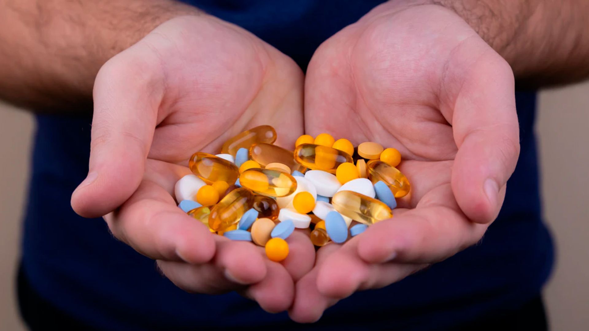 A pile of multi-colored pills in someone's hands. Volodymyr Hryshchenko